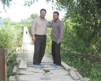 آقا ابوالقاسم اسفندیاری در کنار آقا روح الله پیرداده بر روی یک پل چوبی قدیمی