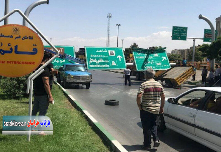 سقوط یک تابلوی تبلیغاتی روی ٢ خودرو جرثقیل در میدان قائم مشهد