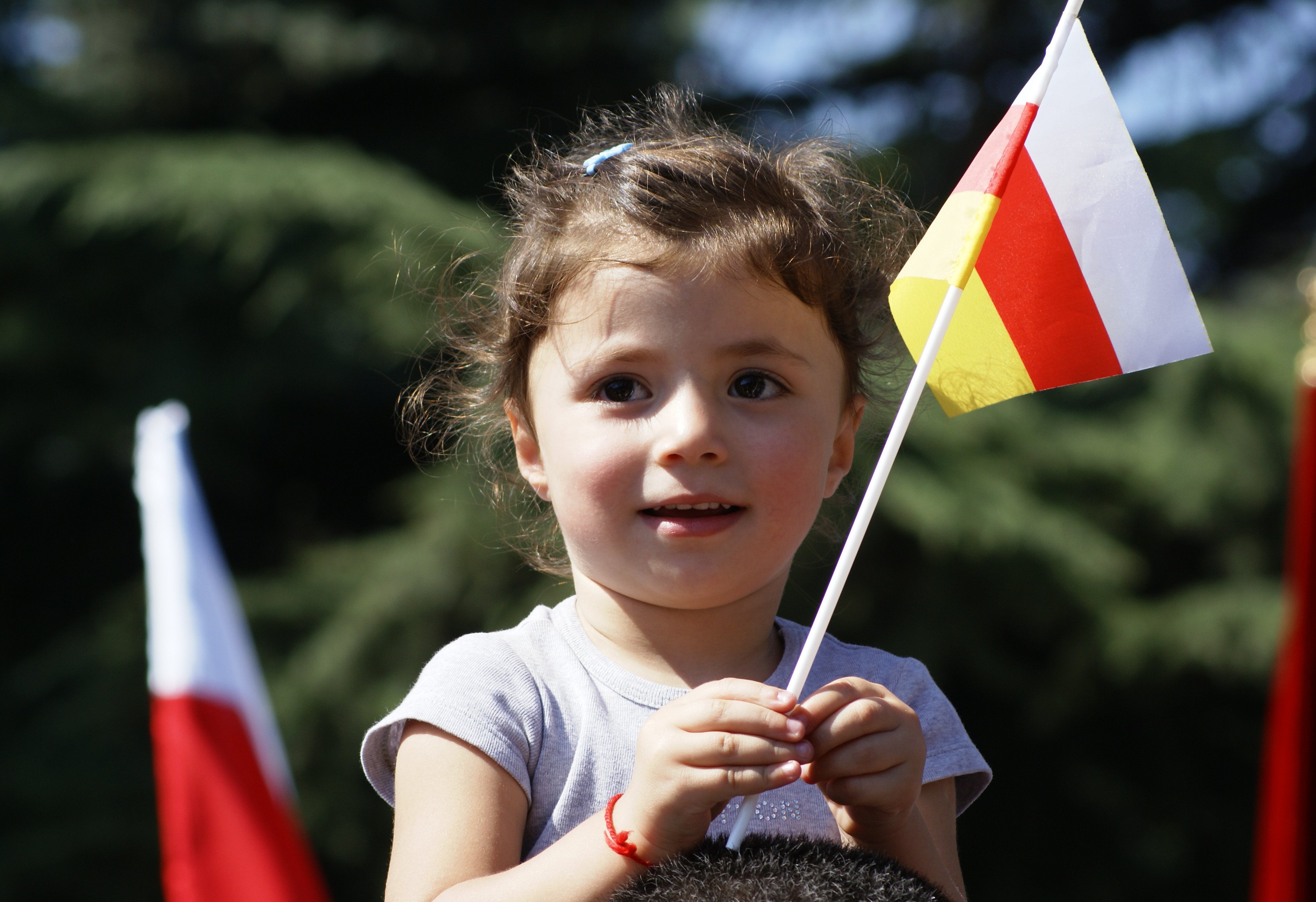 دختر بچه آسی که پرچم اوستیا در دست دارد