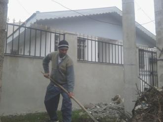 علی باقر پور رئیس شورا در حال جمع آوری زباله و تمیز کردن حاشیه خانه فرهنگ روستای چاپارخانه