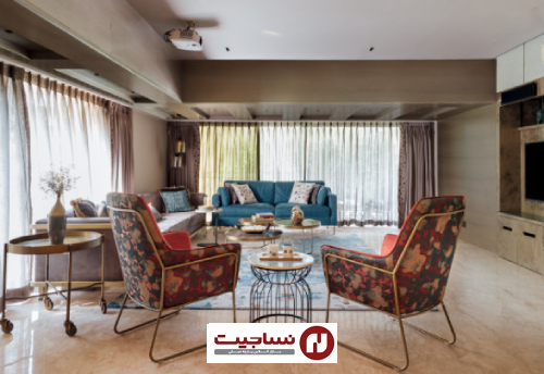 یک جفت صندلی با پشتی طرح‌دار به روشنایی و افزایش رنگ مبل‌های آبی و خاکستری در این اتاق نشیمن می‌افزاید.